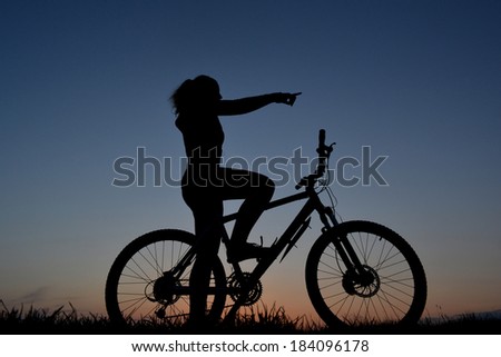 Mountain biker girl silhouette in sunset