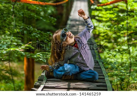 boy in glasses are flying game on suspension bridge