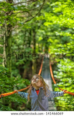 boy looking up at the sky on a suspension bridge