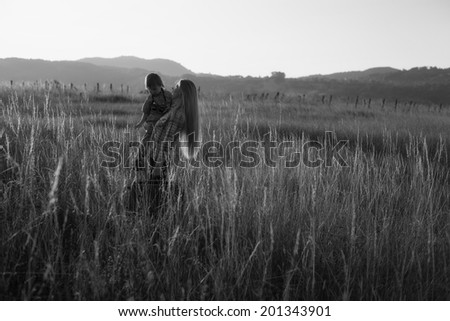 woman with children in a meadow in the twilight days black and white photography