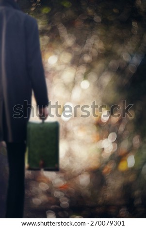 man standing with suitcase in hand, blurred images with beautiful background