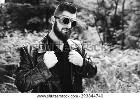 a young man in a leather coat black and white photography
