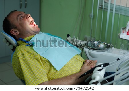patient with the opened mouth in chair of dentist