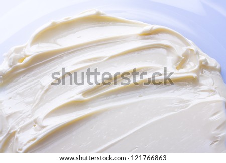 Wavy surface of light beige low-fat milky cream. Close-up photo.