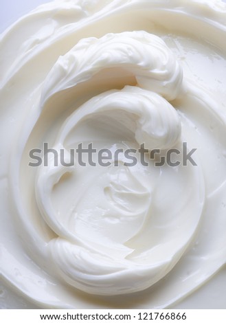 Swirling surface of light beige low-fat milky cream. Close-up photo.