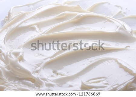 Wavy surface of light beige low-fat milky cream. Close-up photo.