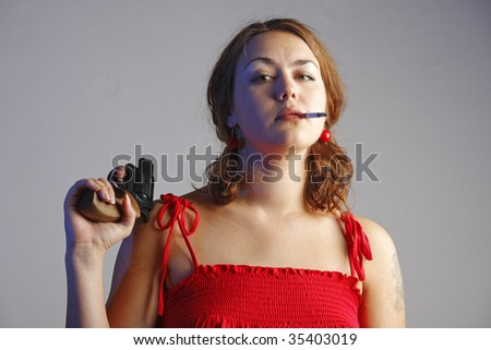 Girl in red is playing with a black revolver and smoking a cigarette