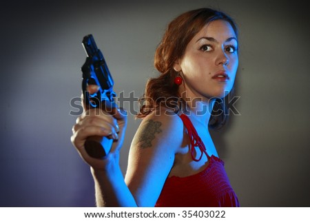 Girl in red is playing with a black revolver