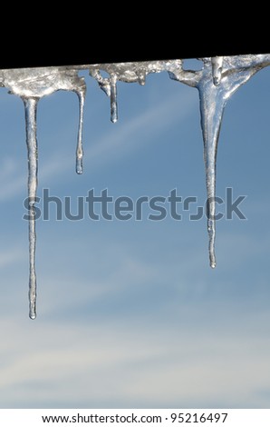 stalactites of ice with water drops under a roof