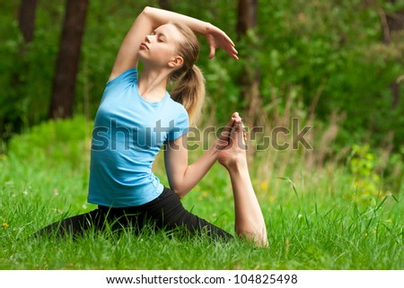 Young beautiful woman doing yoga meditation in forest outdoors