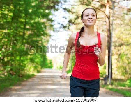 Young beautiful athlete woman jogging outdoors in park