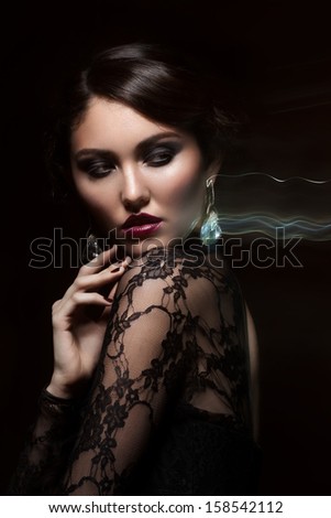 Fashion studio shot of  beautiful young woman with retro hairstyle and elegant earrings