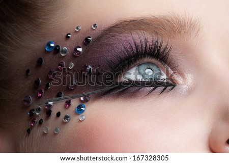 Closeup of Beautiful Woman Eye with Creative Makeup. Eye Makeup, False Eyelashes and Rhinestones