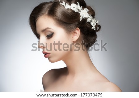Portrait of a young beautiful woman with bridal hairstyle and makeup