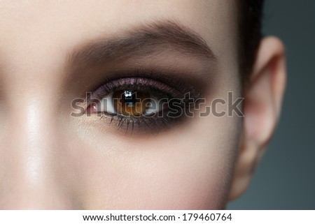 Closeup of beautiful woman eye with bright stylish makeup with long lashes