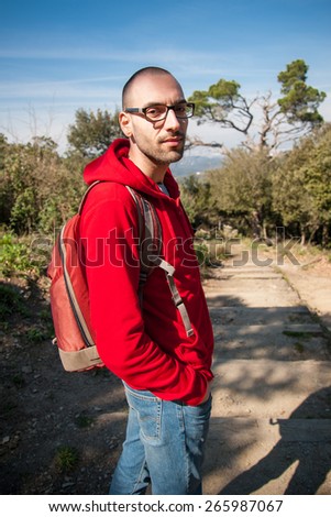 Young man backpacker tourist in park looking at camera