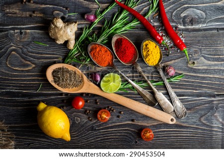 Spices. Herbs and spices selection in old metal spoons over wooden background. Rosemary, lemon and chili pepper.