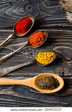 Spices. Herbs and spices selection in old metal spoons over wooden background. Curry, Saffron, turmeric, cinnamon and other.