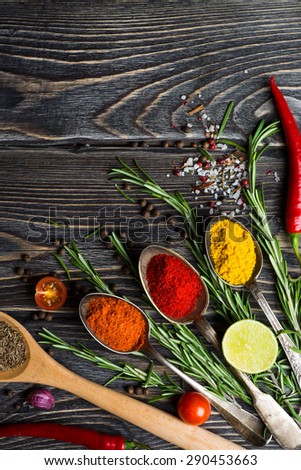 Spices. Herbs and spices selection in old metal spoons over wooden background. Rosemary, lime and chili pepper.