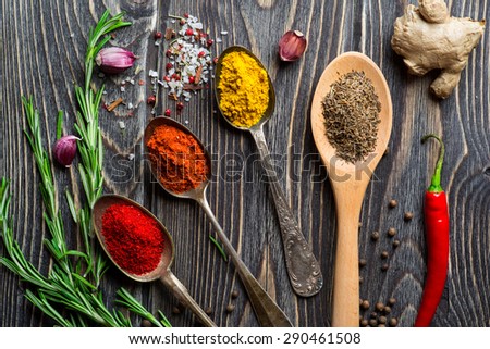 Spices. Herbs and spices selection in old metal spoons over wooden background. Rosemary, ginger and chili pepper.