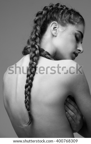 Young beautiful woman with beautiful braids covering herself by hands