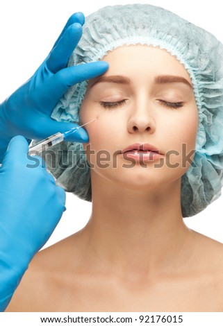 Close-up shot of cosmetic injection to the pretty female face. Isolated on white background