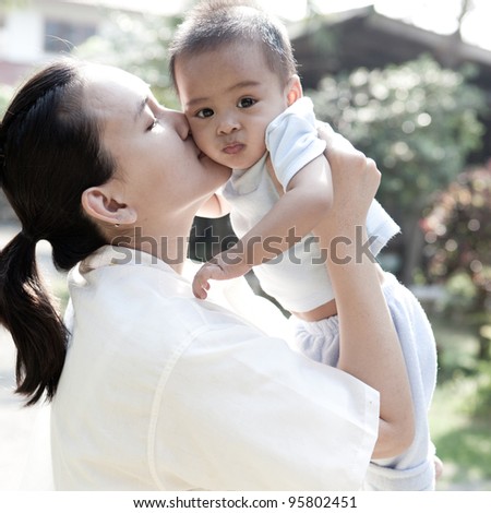 Asian mom kissing her son
