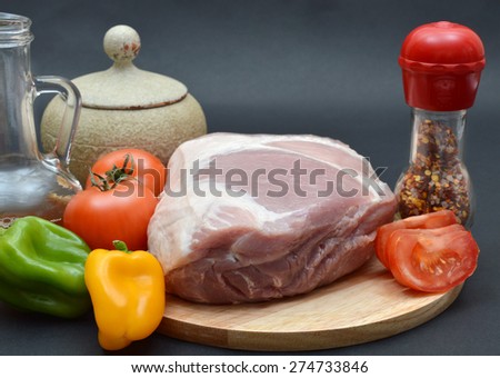 Pork shoulder and vegetables on cutting board.