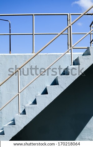 Blue concrete stairs with galvanized railing pipes