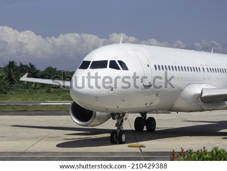 Commercial airplane on tarmac waiting to be serviced by ground crew