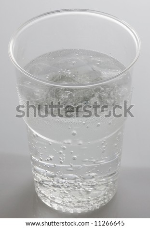 Clear carbonated drink against white