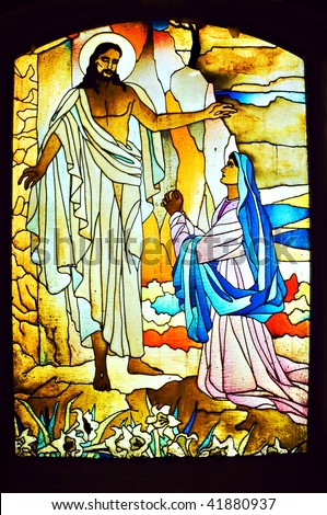 Stained glass depicting a woman praying to Jesus