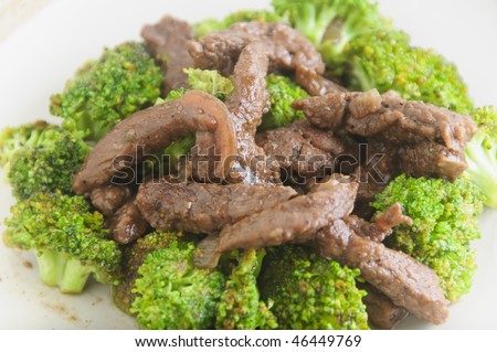 Close-up of beef broccoli on plate; shot against white background