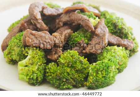 Close-up of beef broccoli on plate; shot against white background