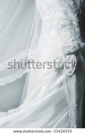 Close-up of white wedding gown on plain background