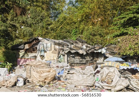 Sacks and sacks of garbage in front of a shanty