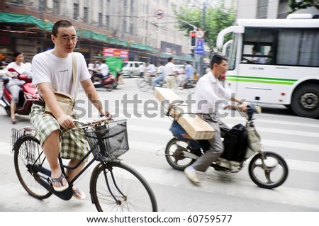 SHANGHAI - AUGUST 21: Unidentified men ride their bicycles in Shanghai on August 21, 2009.  Bicycles are a common form of transportation in China.