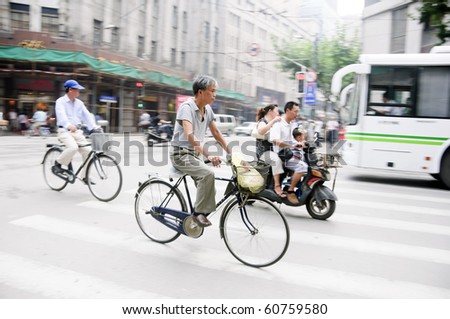 SHANGHAI - AUGUST 21: Unidentified men ride their bicycles in Shanghai on August 21, 2009.  Bicycles are a common form of transportation in China.