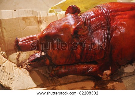 Close-up of roasted pig still on carton