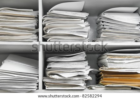 Three stacks of office folders in open shelves