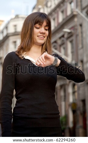 Woman checking the time on her watch - outdoors