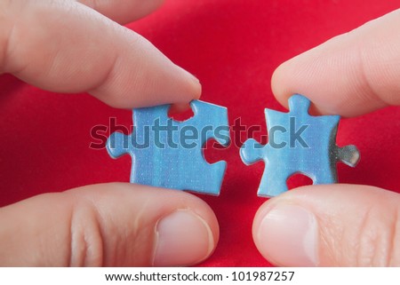 Connecting two puzzles. On a red background.