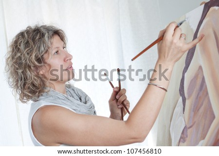 Woman artist draws a portrait of a woman.