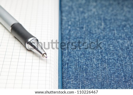 Named ballpoint pen. On the background of notebooks and jeans.