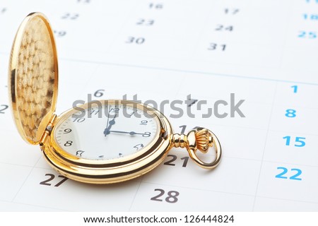 Antique pocket watch on a calendar.