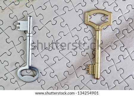 Keys to puzzles closeup gold and silver.