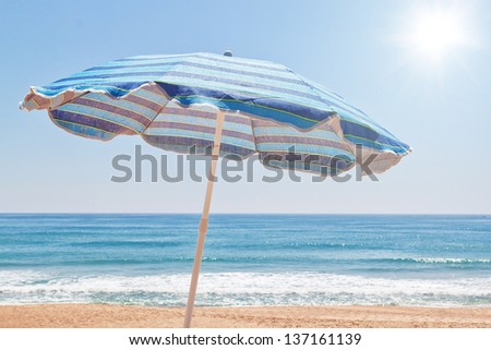Blue for sun umbrella on the beach near the sea.