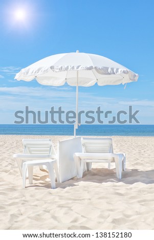 Beautiful white beach umbrella and sun bed on a sunny beach. For the rest.