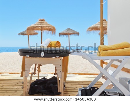Massage area and a deck chair on the beach for therapy. Near the sea.
