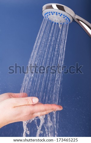 Water Pours Out Of The Shower On The Girl\'S Hands. On A Blue Background.